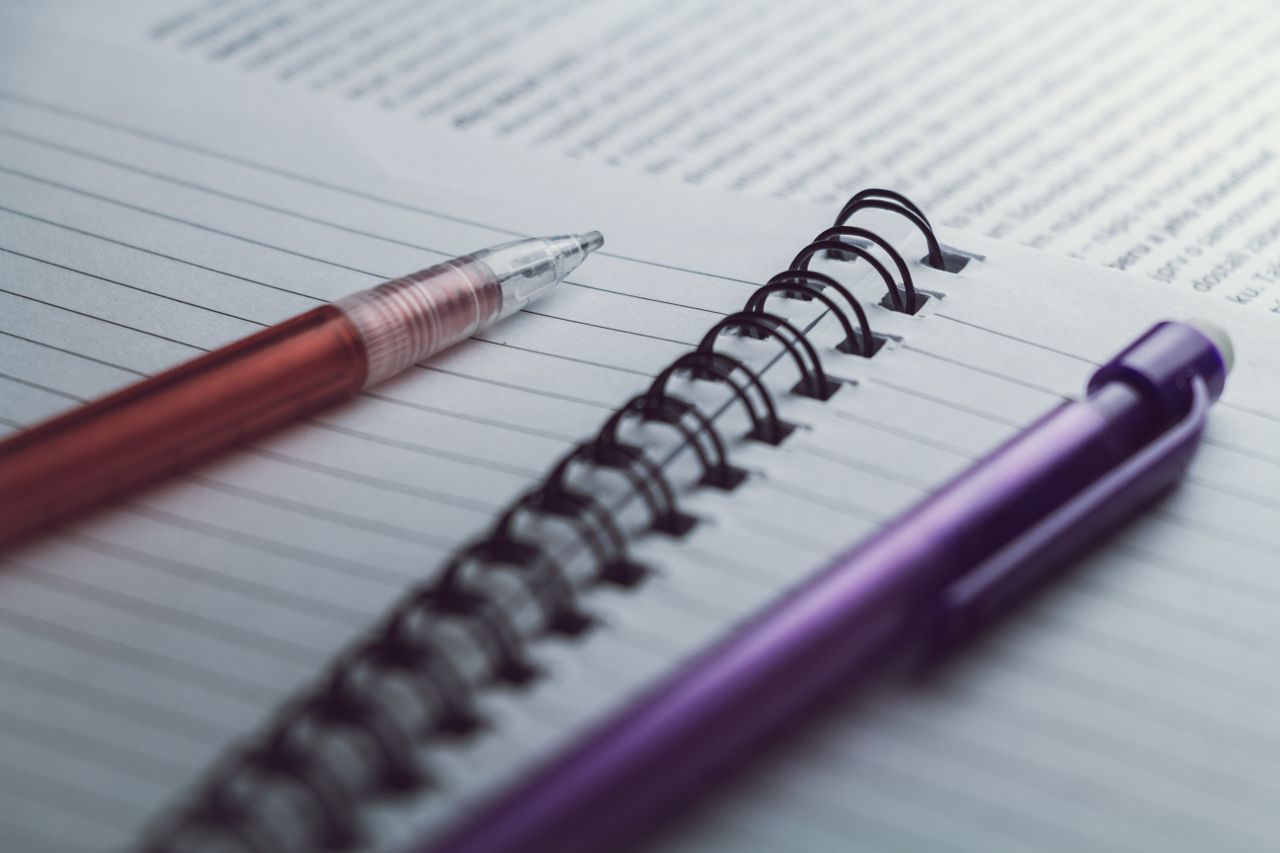A detailed view of spiral notebooks and pens, perfect for office or school settings.